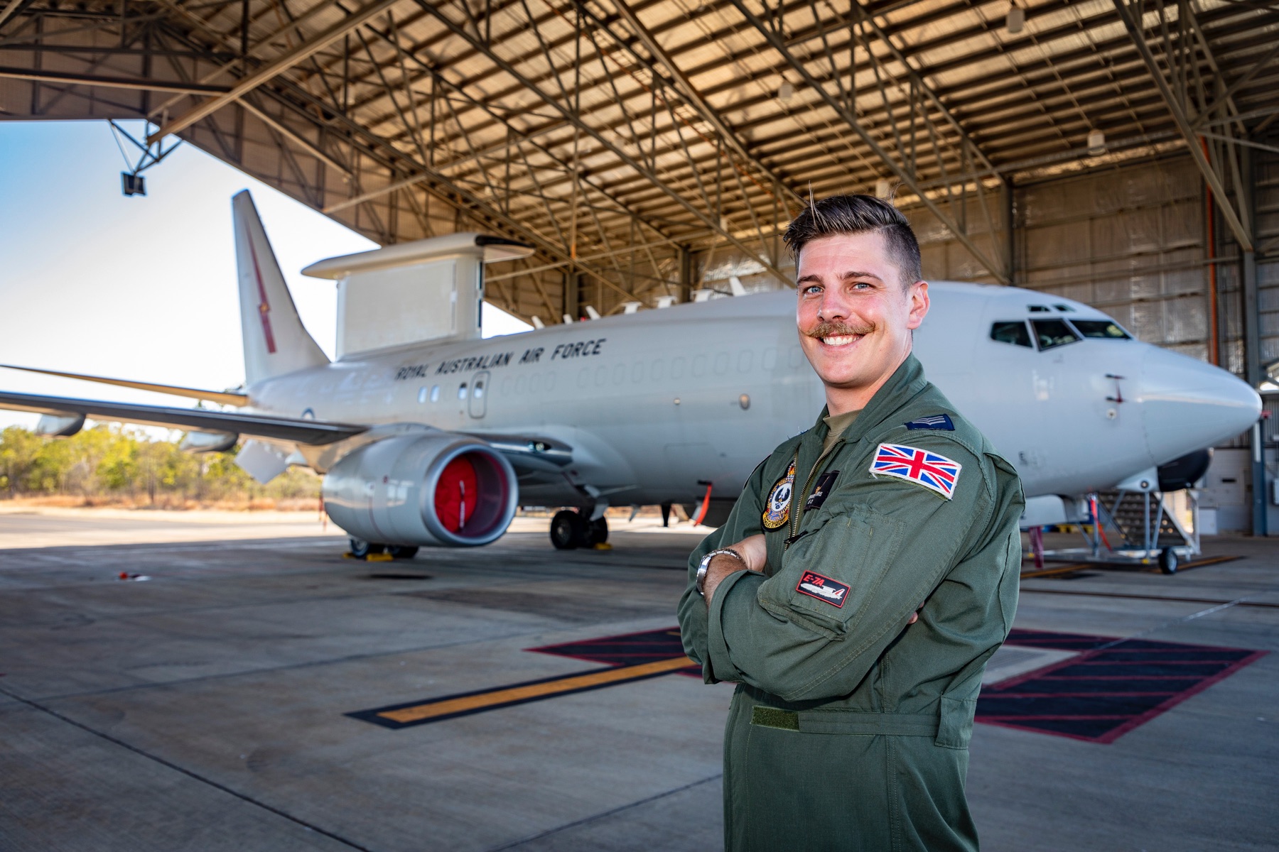 Image shows RAF aviator standing by the Wedgetail aircraft in a hangar.